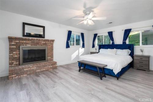 une chambre avec un lit bleu et une cheminée dans l'établissement Mountain Retreat! 4 BDR, 2 BTH Yosemite, Bass Lake, à Oakhurst