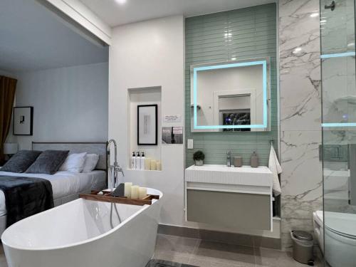 a bathroom with a bed and a tub and a sink at Cozy 2 Bedroom with Parking in Toronto