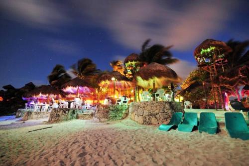 a beach with chairs and umbrellas at night at Akumal Skies Private Terrace W Jacuzzi W Sea Views Walk To Beach in Akumal