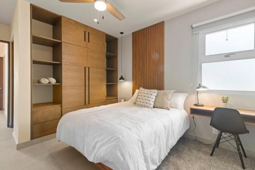 a bedroom with a bed and a desk and a window at Akumal Skies Private Terrace W Jacuzzi W Sea Views Walk To Beach in Akumal