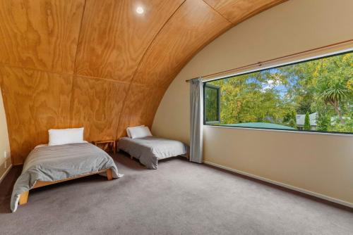 a room with two beds and a large window at Modern Barn Style - Taupo Holiday Home in Kinloch