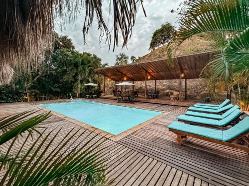 a pool with blue lounge chairs on a wooden deck at Hotel Isabella Tayrona in Los Naranjos