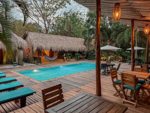 a resort with a swimming pool and tables and chairs at Hotel Isabella Tayrona in Los Naranjos