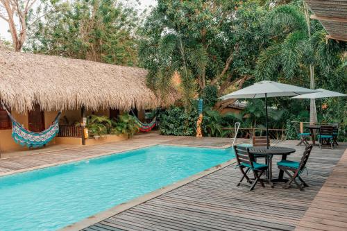 a pool with a table and chairs and an umbrella at Hotel Isabella Tayrona in Los Naranjos