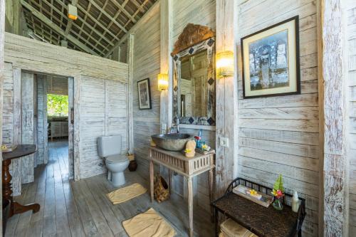 a bathroom with a toilet and a sink at Villa Sungai Laut in Canggu