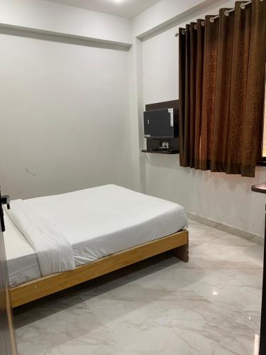 a bedroom with a bed and a tv on the wall at AMALTAAS HOMESTAY in Gwalior