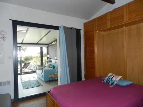 - une chambre avec un lit violet et une porte coulissante en verre dans l'établissement Appartement 2 pièces 4 pers avec parking et espace extérieur au Lavandou - FR-1-251-792, au Lavandou