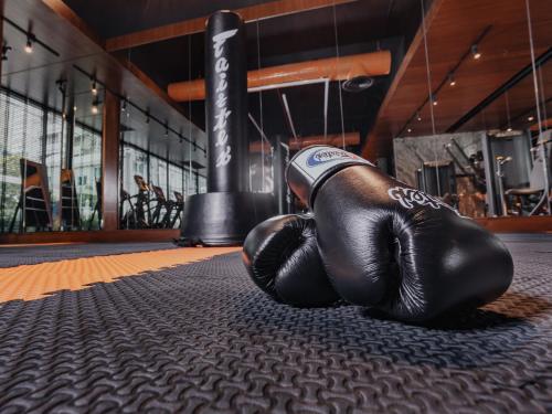 a pair of boxing gloves sitting on a mat in a gym at Nysa Hotel Bangkok Sukhumvit 11 in Bangkok