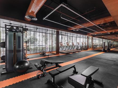 a gym with a row of treadmills and weights at Nysa Hotel Bangkok Sukhumvit 11 in Bangkok