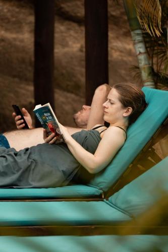 a man and woman laying on a hammock reading a book at Hotel Isabella Tayrona in Los Naranjos