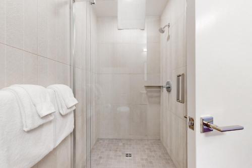 uma casa de banho branca com um chuveiro e toalhas brancas em Pioche Village #1226 em Park City
