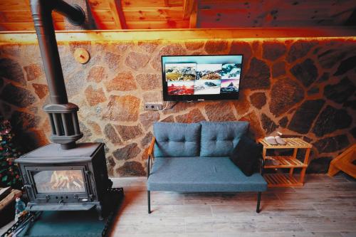 a room with a fireplace and a blue couch and a stove at Golden Rose Bungalov in Ardeşen