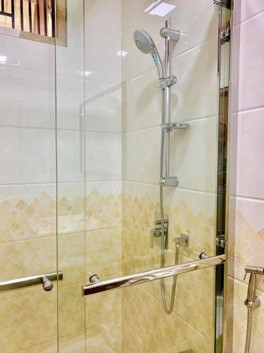 a shower in a bathroom with a glass door at Endhaa, Divers Home in Fuvahmulah
