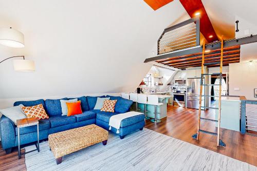 a living room with a blue couch and a kitchen at The Blue Beaver Cottage in Rogers