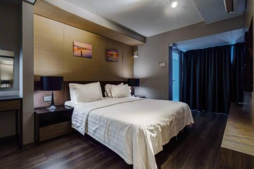 um quarto com uma grande cama branca e uma janela em Seaview Maritime Suite Pool 2Carparks em Jelutong