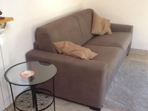 a brown couch and a table in a living room at Mansarda Monte Bianco in La Salle