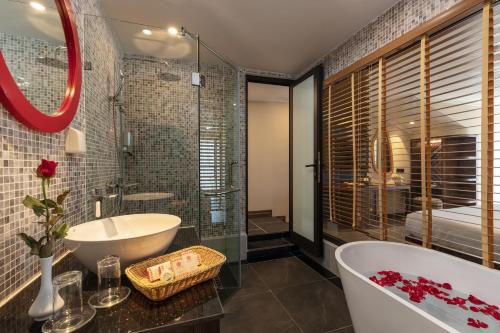 een badkamer met een bad, een wastafel en een bad bij Hôteldesapa in Sa Pa