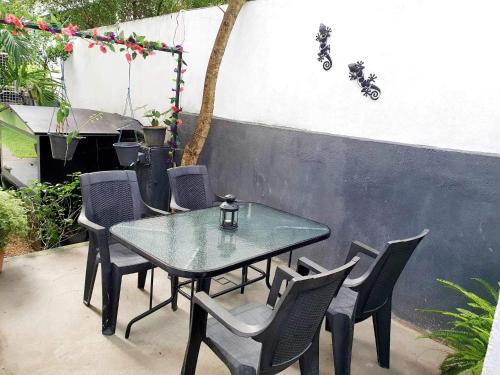 une table et des chaises en verre sur la terrasse dans l'établissement Home From Home, à Nugegoda