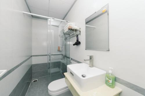 uma casa de banho com um lavatório, um chuveiro e um WC. em Mat Troi Vang Dalat Hotel em Da Lat