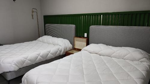 two beds sitting next to each other in a room at WUER Expiatorio in León