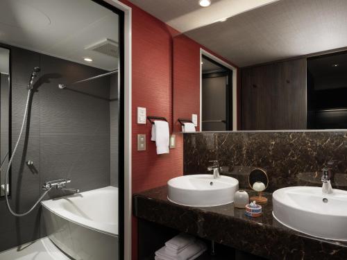 a bathroom with two sinks and a bath tub at MIMARU Osaka Shinsaibashi West in Osaka