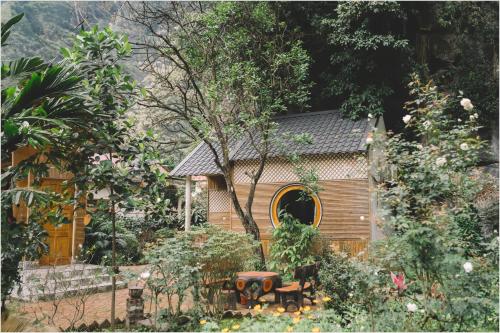 a garden with a small house in the background at Trang An Mountain House in Ninh Binh
