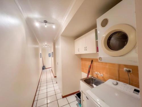 une petite cuisine avec un évier et un micro-ondes dans l'établissement La Riviera One - Coastal Lifestyle - Three Bedroom, à South Mission Beach