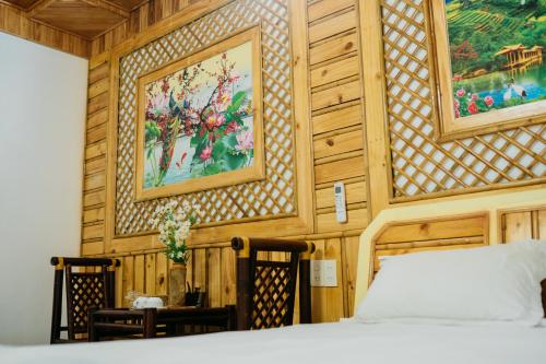 a bedroom with a bed and paintings on the wall at Trang An Mountain House in Ninh Binh
