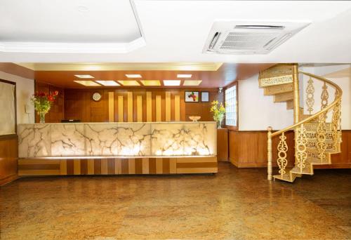 a lobby with a staircase in a building at Monarch Brigade Road in Bengaluru