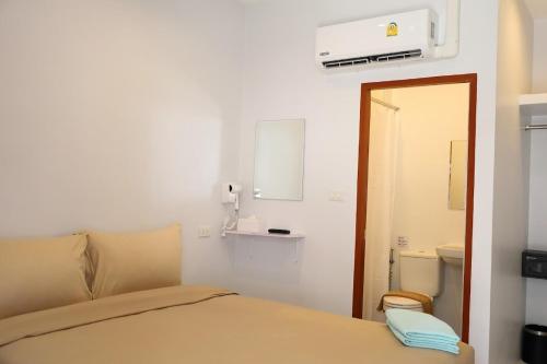 a small bedroom with a bed and a mirror at Y House Patong in Patong Beach