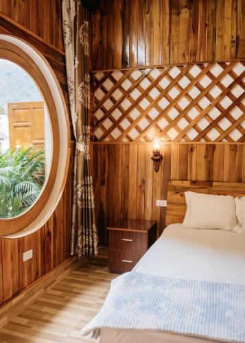 a bedroom with a bed and a large window at Trang An Mountain House in Ninh Binh