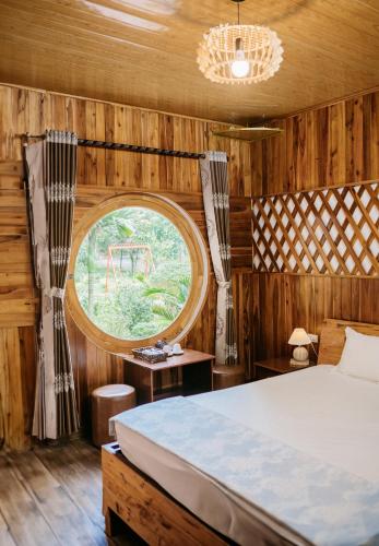 a bedroom with a bed and a round window at Trang An Mountain House in Ninh Binh