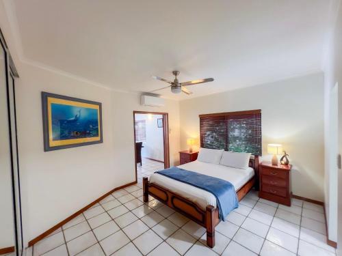 South Mission BeachにあるLa Riviera One Coastal Life Style Two Bedroomのベッドと天井扇風機のある寝室