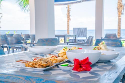 a table with bowls and plates of food on it at Ocean Paradise Bali in Buleleng