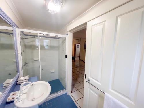 une salle de bain avec un lavabo et une douche en verre dans l'établissement La Riviera One Coastal Life Style One Bedroom, à South Mission Beach