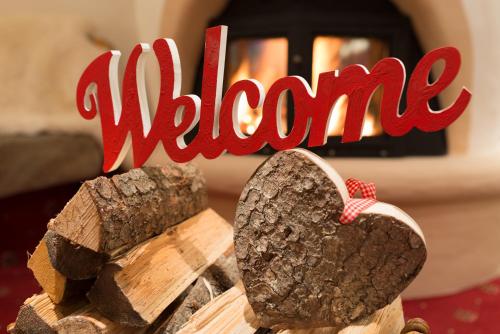 a sign that says welcome next to a wooden heart at Hotel Hubertushof - Ihr Hotel mit Herz in Leutasch