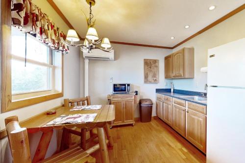 a kitchen with a wooden table and a refrigerator at Blue Line Resort (All 3 Cabins) in Carbondale