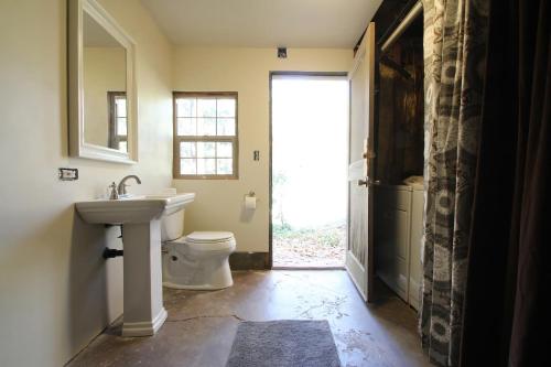 bagno con servizi igienici, lavandino e finestra di Ahwahnee-be Vintage Cabin - Walk to town! a Idyllwild
