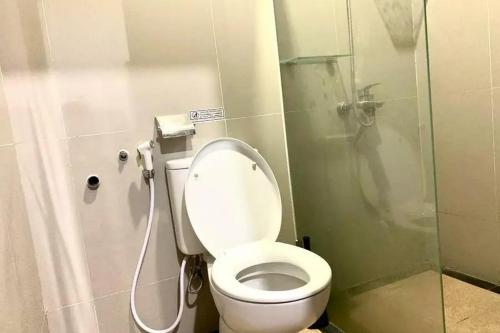 a small bathroom with a toilet and a shower at Rumah Daun Timoho Yogyakarta RedPartner in Yogyakarta