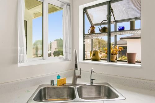 a kitchen sink with two windows above it at Colorful Gold Coast Getaway in Santa Barbara