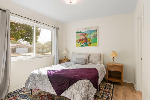 Colorful Gold Coast Getaway في سانتا باربرا: غرفة نوم بيضاء بها سرير ونافذة