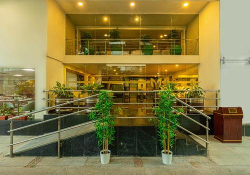 a building with two potted plants in front of it at Monarch Luxur - Infantry Road in Bengaluru