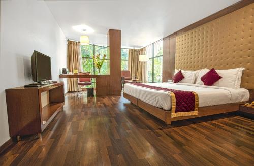 a bedroom with a bed and a flat screen tv at Monarch Luxur - Infantry Road in Bangalore