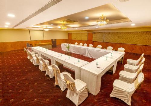 a large conference room with white tables and white chairs at Monarch Luxur - Infantry Road in Bengaluru