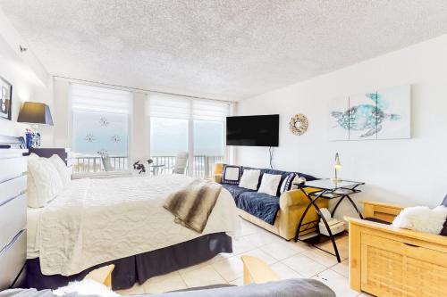 um quarto com uma cama e um sofá em Harbour Beach Resort Unit 518 em Daytona Beach