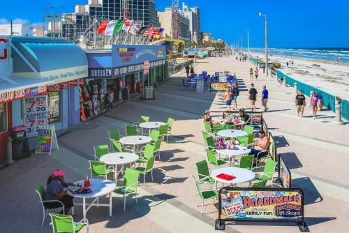 a boardwalk with tables and chairs on the beach at Harbour Beach Resort Unit 518 in Daytona Beach