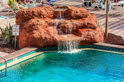 a swimming pool with a waterfall in front of a rock at Harbour Beach Resort Unit 518 in Daytona Beach