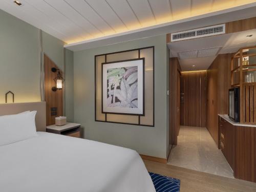 a bedroom with a white bed and a door at Nysa Hotel Bangkok Sukhumvit 11 in Bangkok