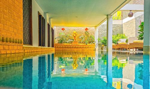 une piscine d'eau dans un bâtiment avec une fontaine dans l'établissement Little Hoi An . A Boutique Hotel & Spa, à Hội An