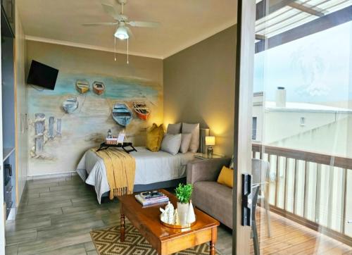 1 dormitorio con 1 cama y 1 sofá en Bliss on JBay - Blissful, en Jeffreys Bay